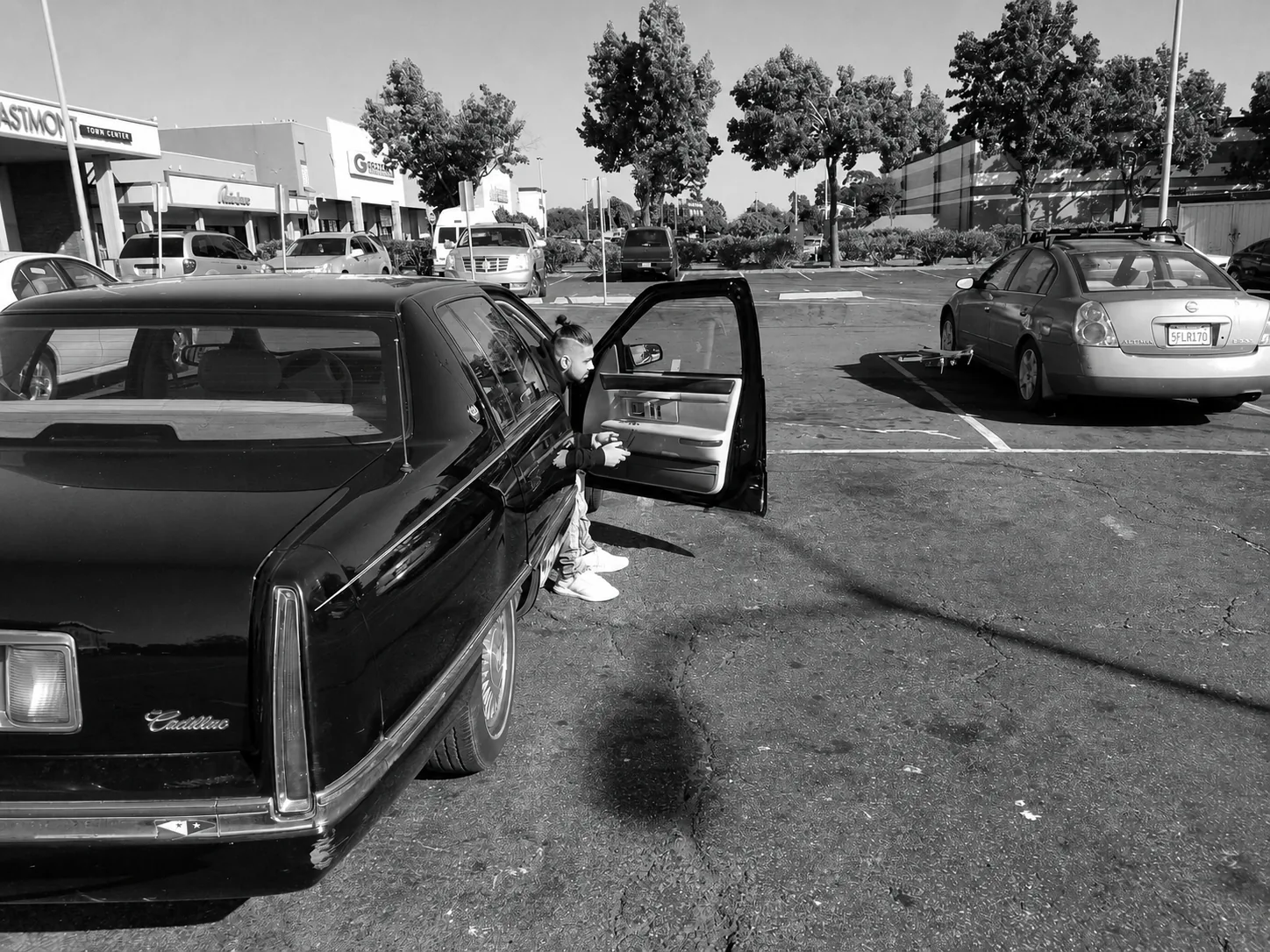 Ham seated in the open door of a Cadillac.